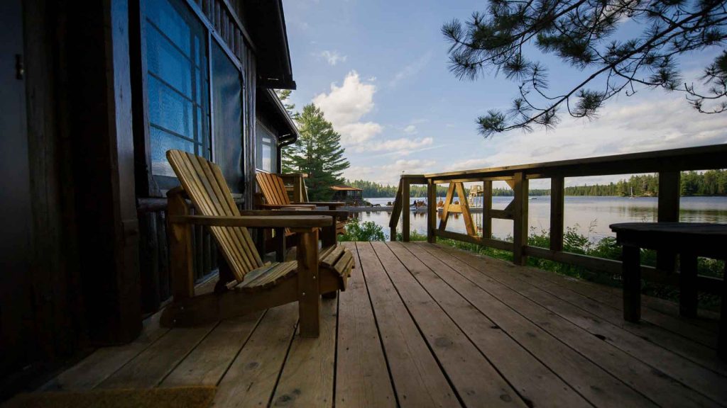 Timber deck with wooden chairs overlooking a lake