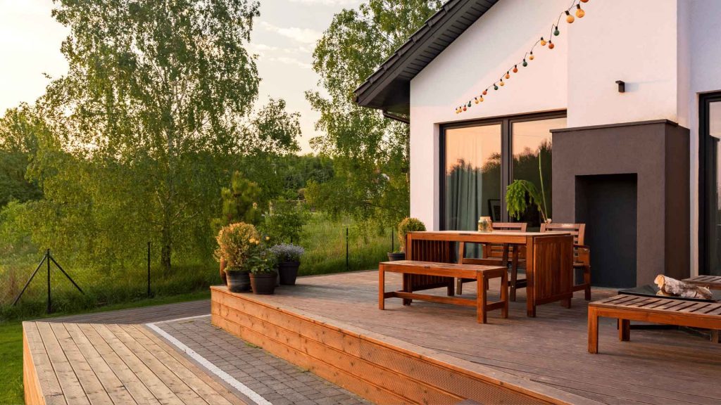 Timber deck with outdoor dining furniture beside a house