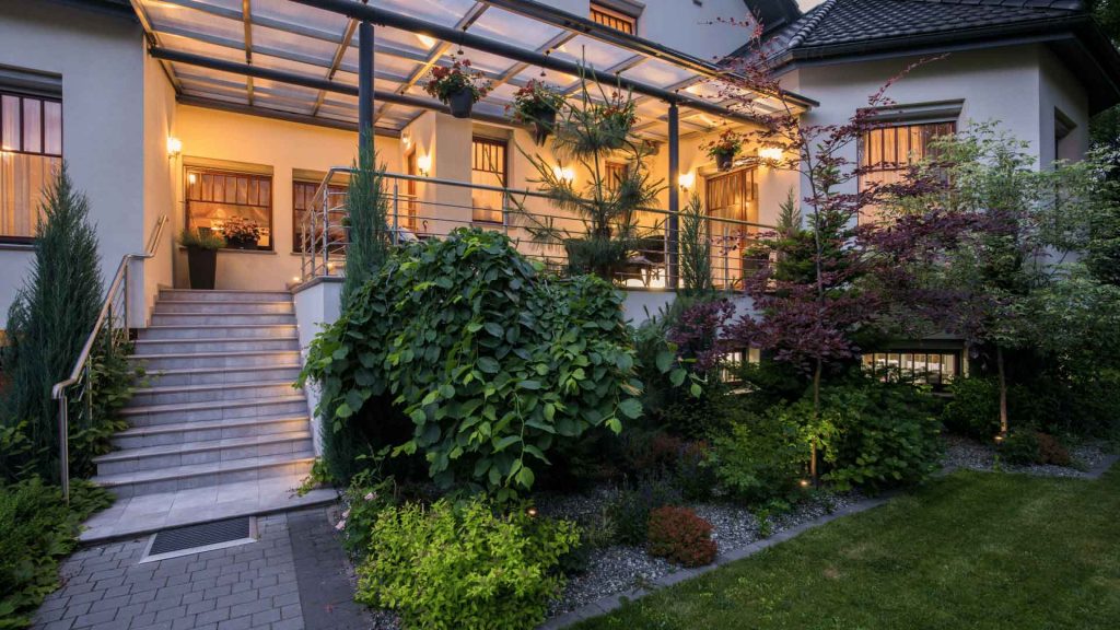 Covered entry stairway and verandah on a home, lit at dusk